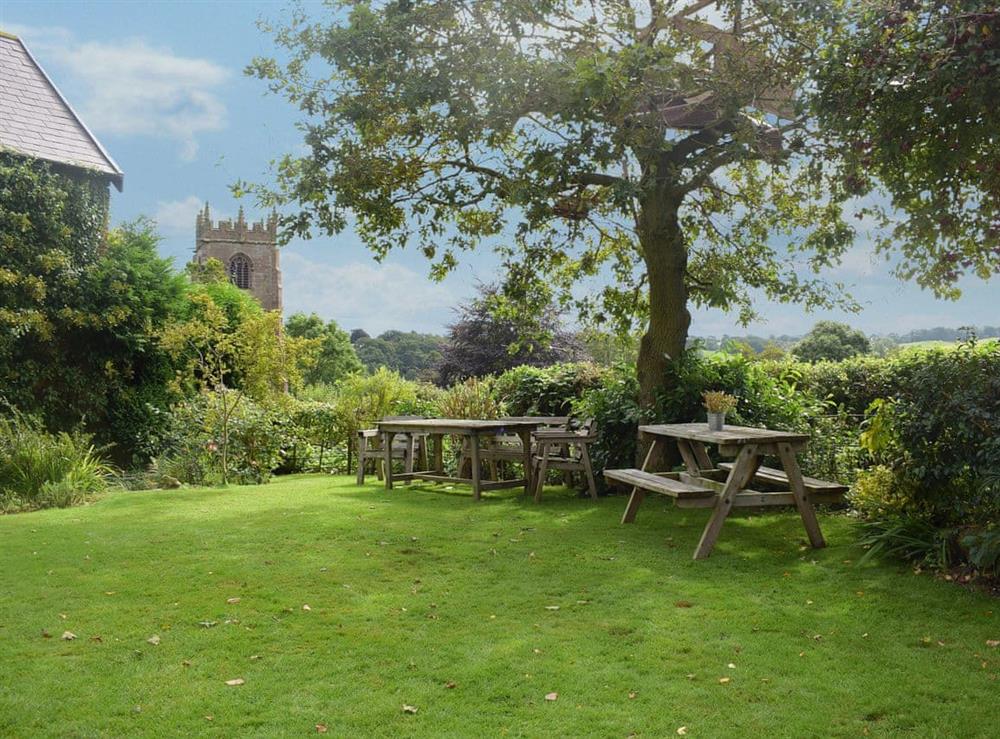 Lush garden with picnic style seating at The Garden Retreat in Marbury, near Whitchurch, Hampshire