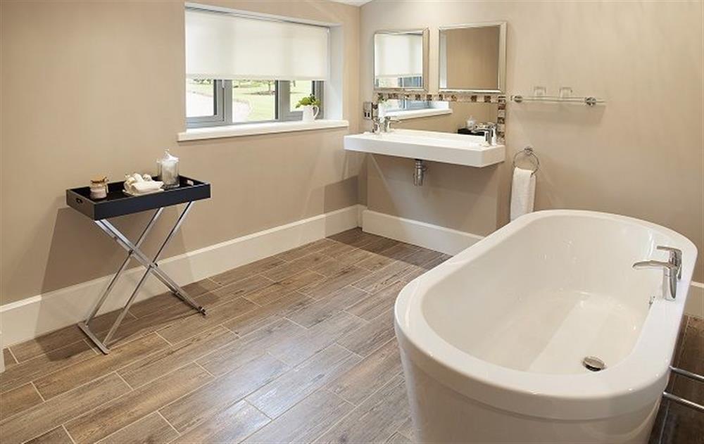 En-suite bathroom with underfloor heating, double sink and bath for two at The Gardeners Bothy, Weston Park