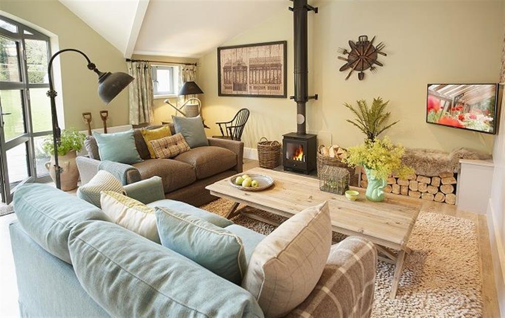 Open plan sitting room with wood burning stove at The Gardeners Bothy, Weston Park
