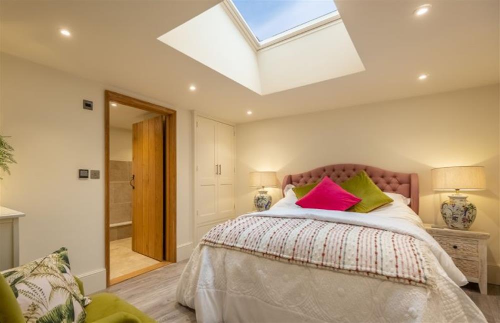 Ground floor: Master bedroom with king size bed and door to ensuite at The Gardeners Cottage, Earsham near Bungay
