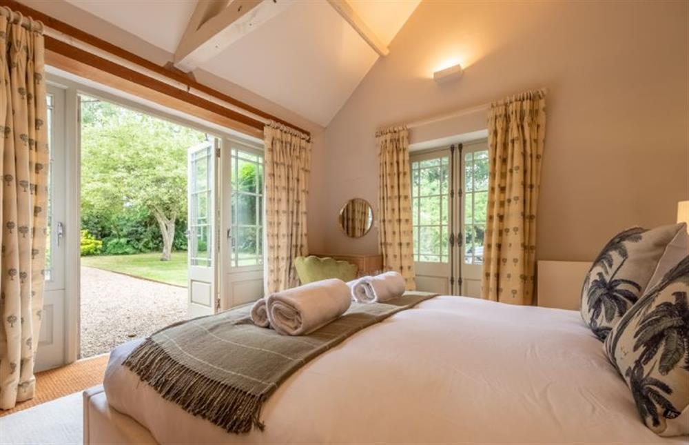 A dual aspect bedroom with double doors to the garden at The Gardens, Burnham Market near Kings Lynn