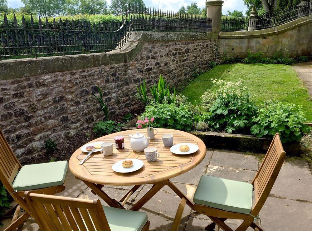 Enclosed lawned garden and patio with furniture at The Gatehouse at Beckfoot Hall in Kirkby Stephen, near Appleby, Cumbria