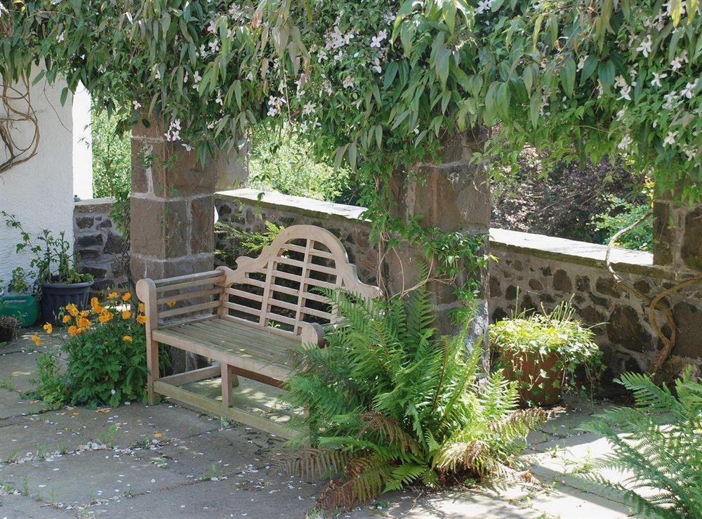 Lutyens bench situated in the shady courtyard