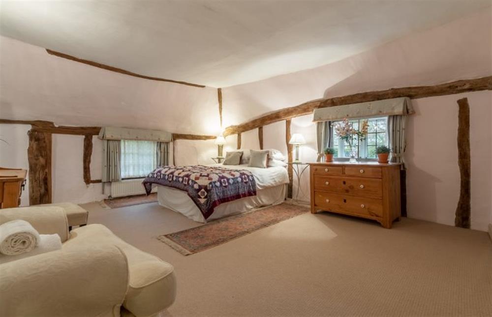 Bedroom with king-size bed and door through to bathroom at The Gildhall, Higham