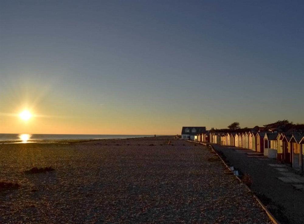 Local beach with beach-huts at sunset at The Glade in Ferring, Worthing, West Sussex