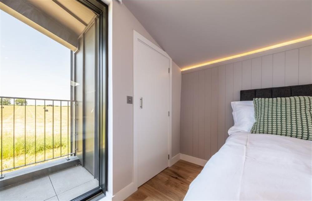 Doors open to reveal a balcony shared with bedroom four at The Grain Store, Reepham
