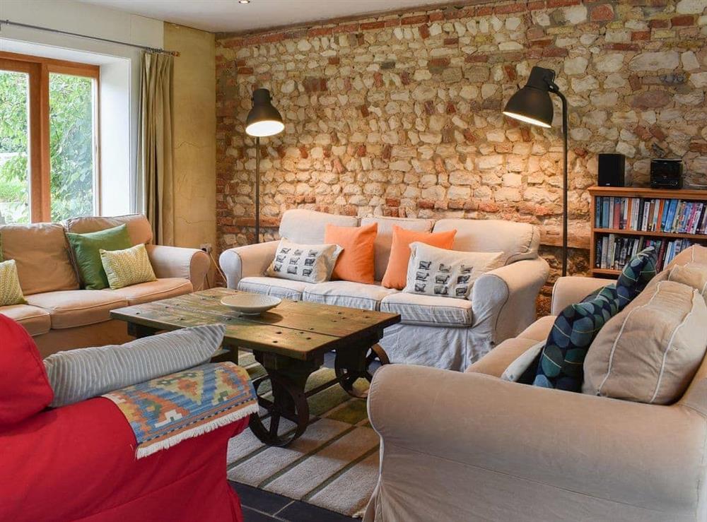 Cosy and comfortable living room with feature stone wall at The Granary in Oxborough, Norfolk., Great Britain
