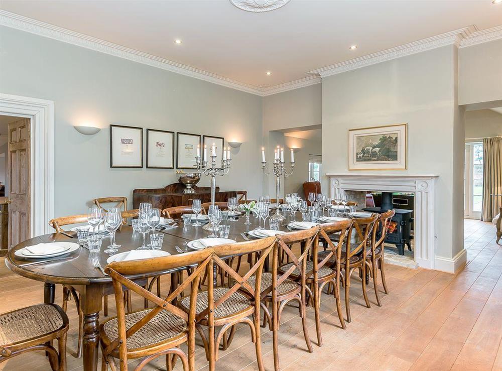 Spacious dining room with with double-sided wood-burning stove at The Grange Farmhouse in Sculthorpe, Norfolk