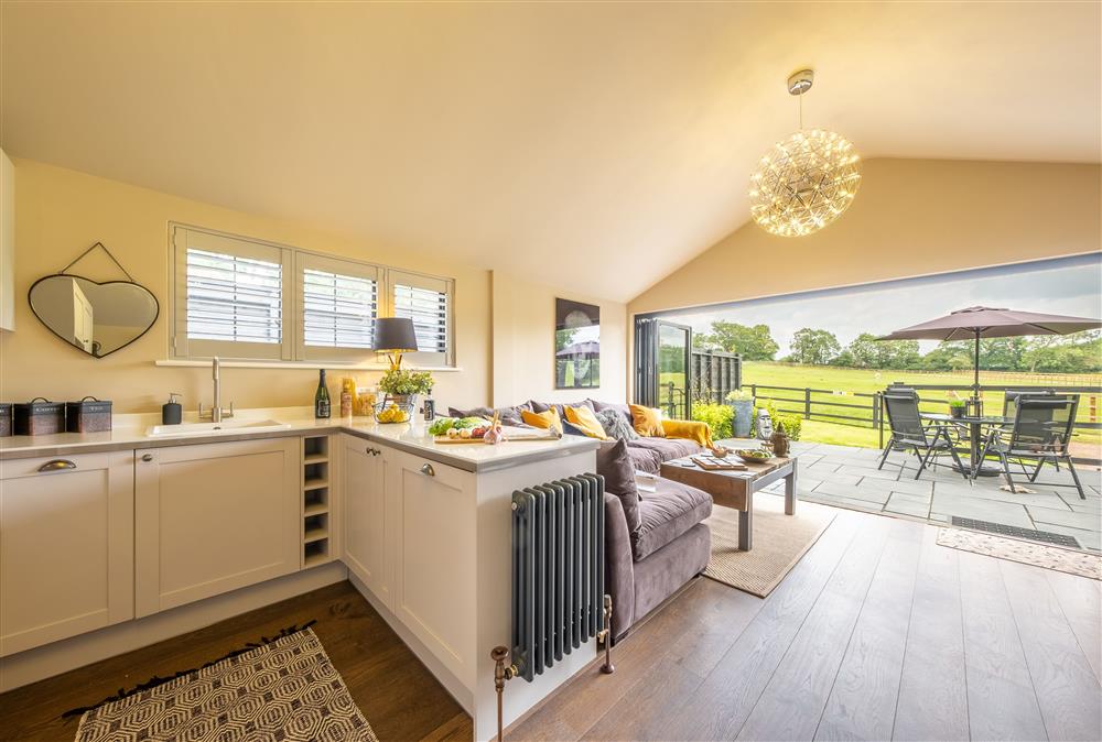 Open-plan kitchen, dining and sitting area with bi-fold doors at The Haybarn, Surrey Hills