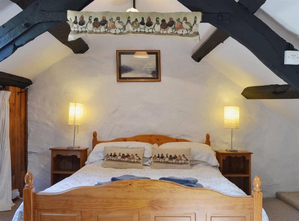 Lovely romantic bedroom with low beams at The Hayloft Barn in near Criccieth, Gwynedd