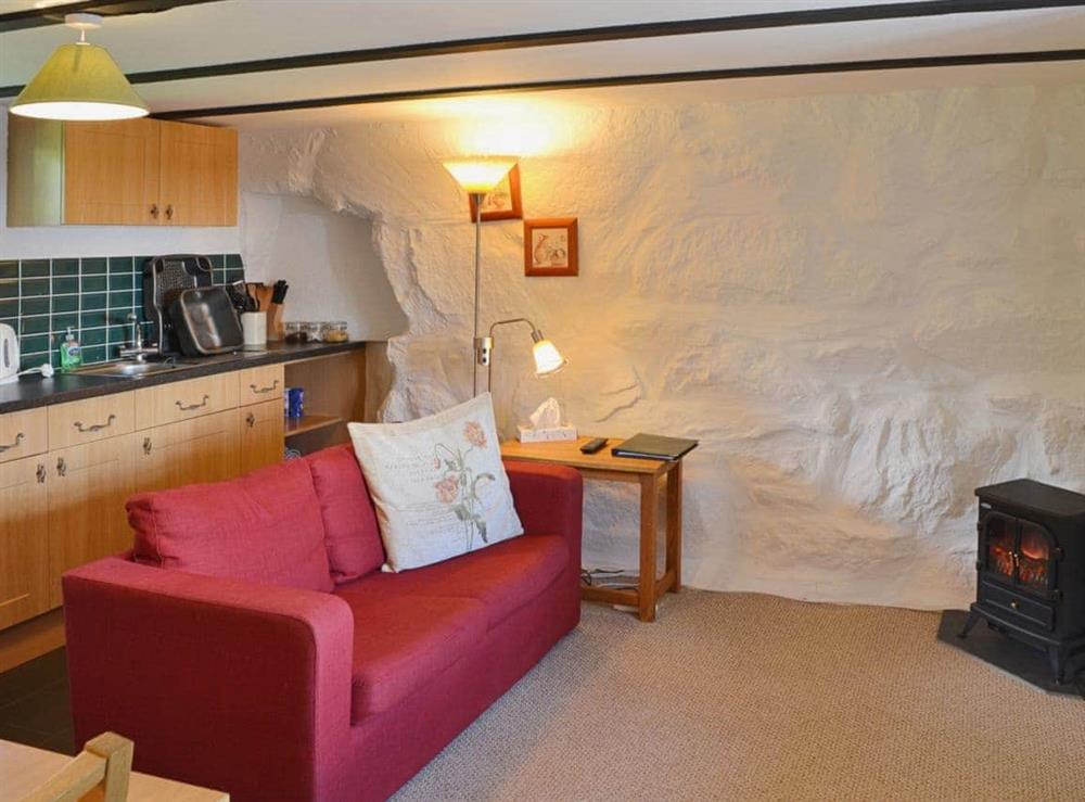 Whitewashed stone walls and comfortable furniture in the open plan living space at The Hayloft Barn in near Criccieth, Gwynedd