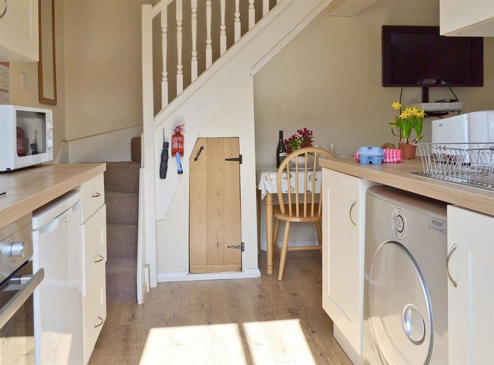 Galley style kitchen with stairs to upper level at The Hayloft in Northiam, near Rye, East Sussex
