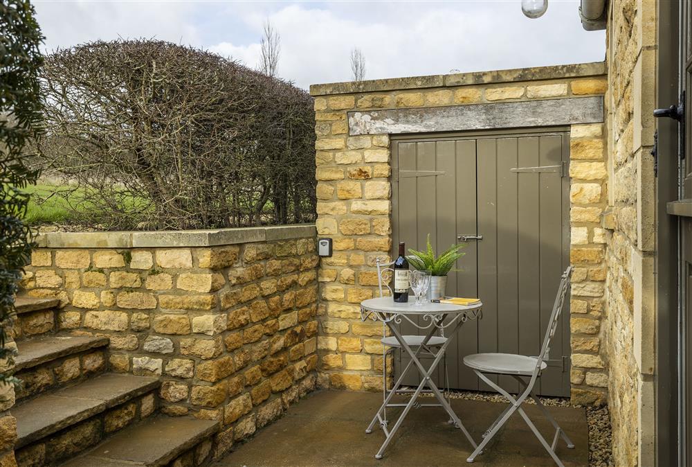 Steps down to the entrance with patio area,  garden furniture and gas barbecue at The Hideaway,  Lower Oddington