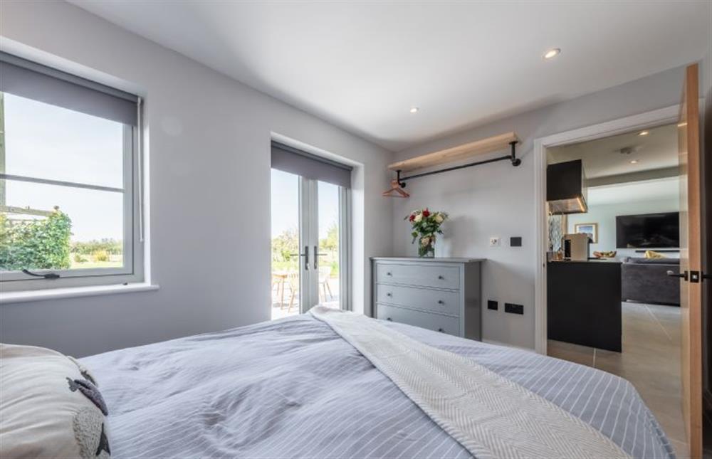 Ground floor: Master bedroom with doors to the garden at The Hideaway, Snettisham near Kings Lynn