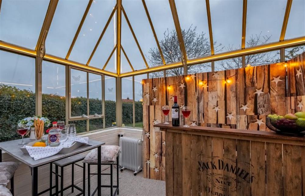 Drinks bar with table and bar stools, fridge and mood lighting at The Homestead, Southrepps near Norwich