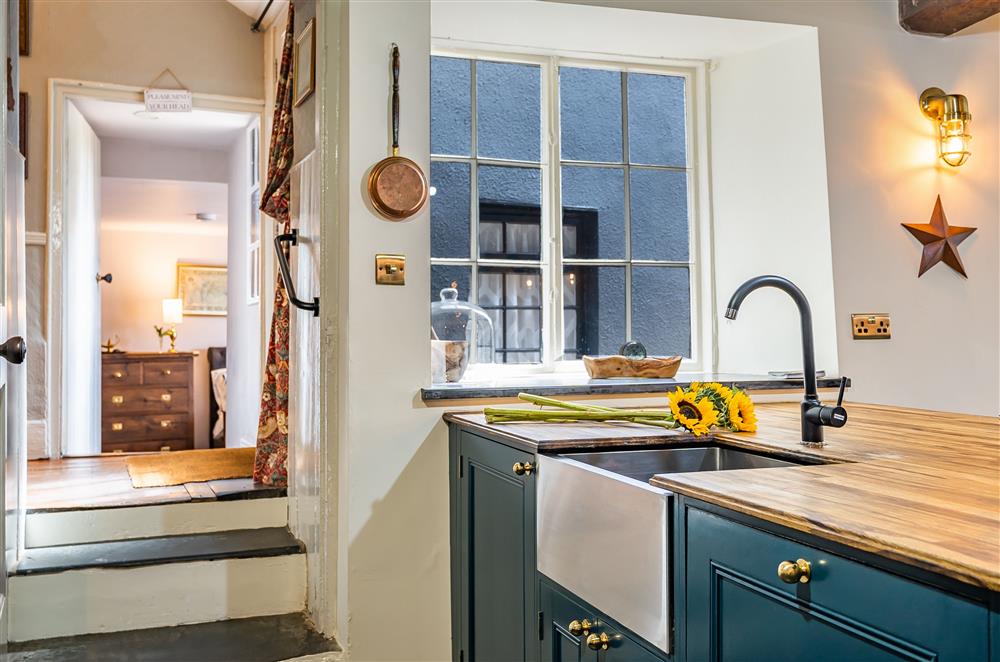 The stylish kitchen area, with steps leading to bedroom one at The House of Black and White, Great Torrington