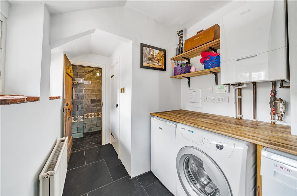 The utility room with a freezer, washing machine and tumble dryer at The House of Black and White, Great Torrington