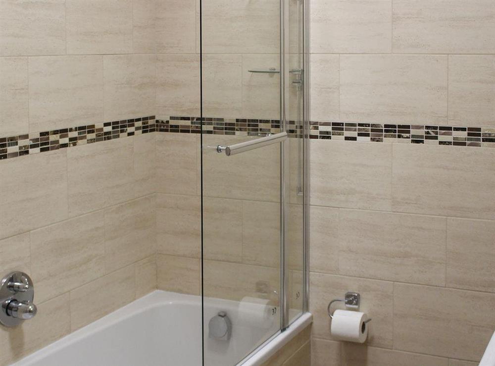 Tiled bathroom with shower over the bath at Apartment 2, 