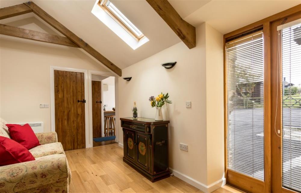 The lounge with French windows (TV is now on the sideboard) at The Little Barn, Tintagel