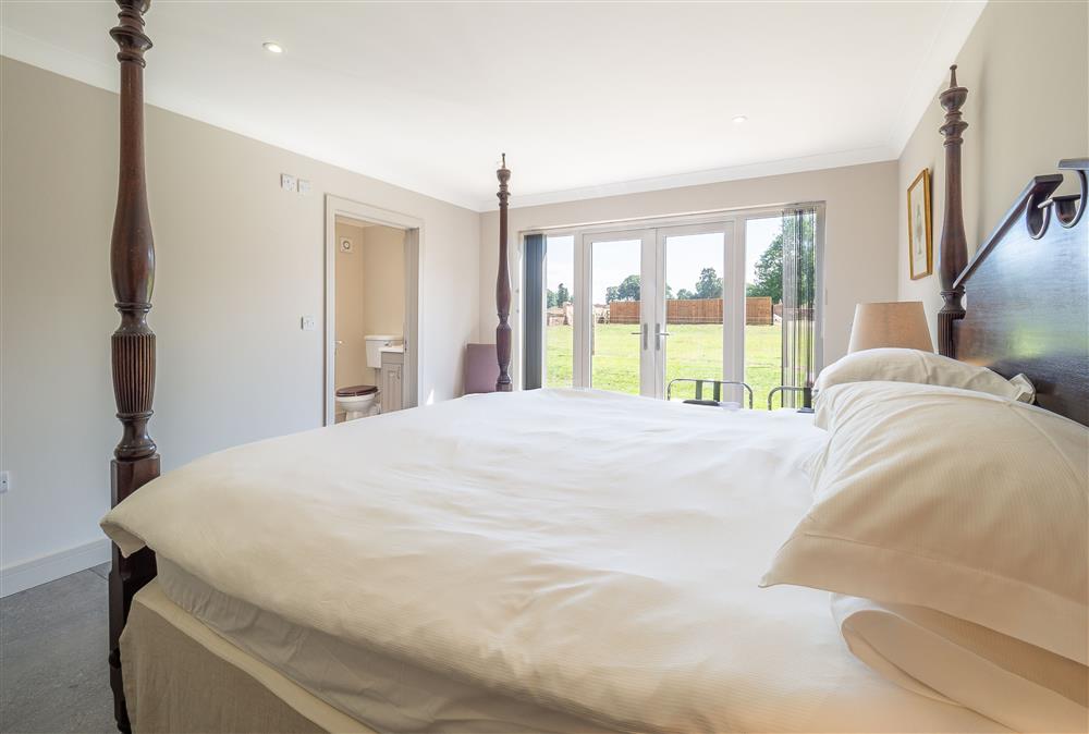 Master bedroom with 6’ super-king size bed and en-suite bathroom at The Lodge, Middleton
