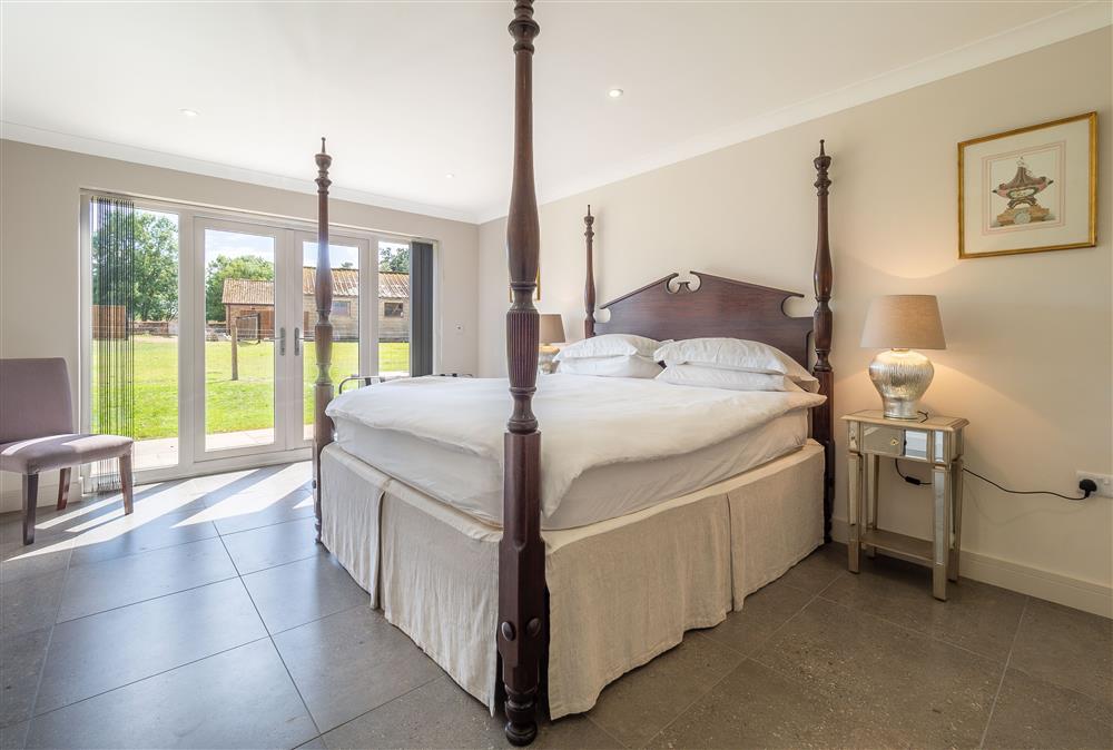 Master bedroom with en-suite bathroom and french doors to the garden at The Lodge, Middleton