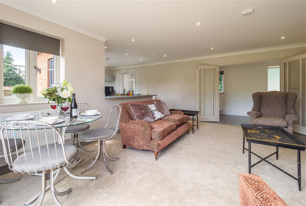 Open-plan living space with sitting area and dining table and chairs at The Lodge, Middleton