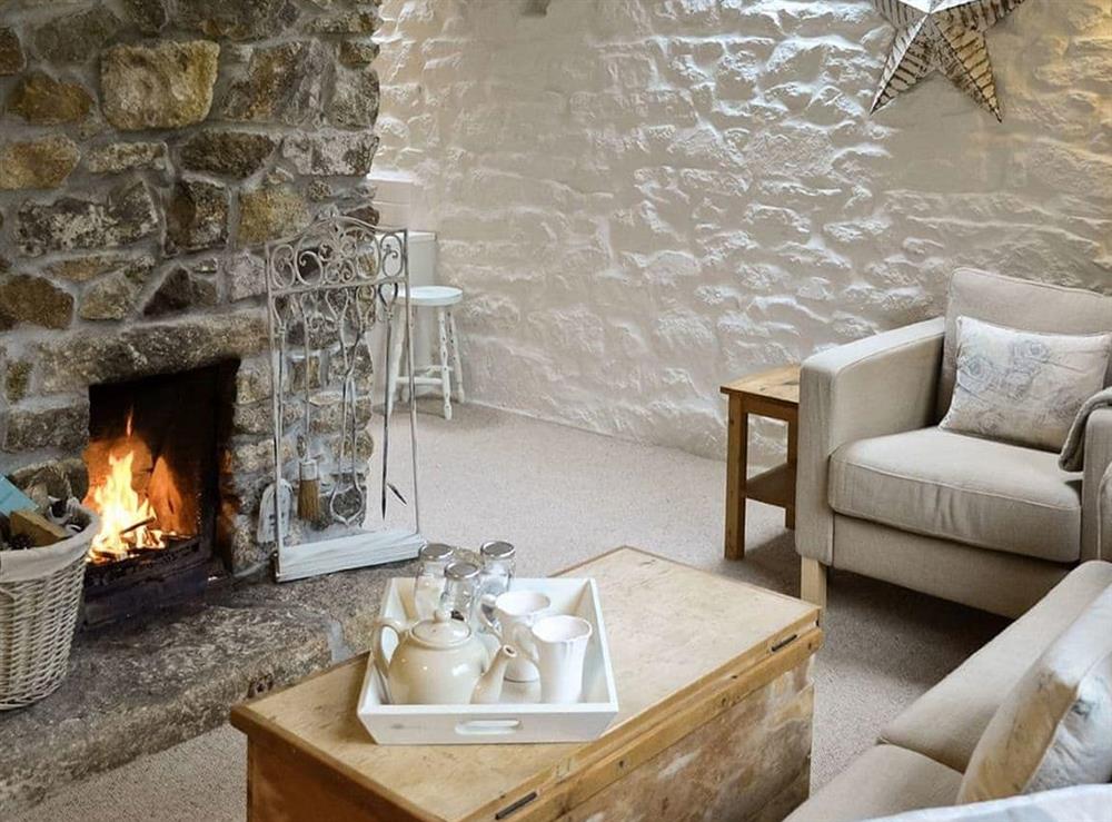 Beautifully presented living room with open fireplace at The Long Barn in Godolphin Cross, Helston, Cornwall., Great Britain