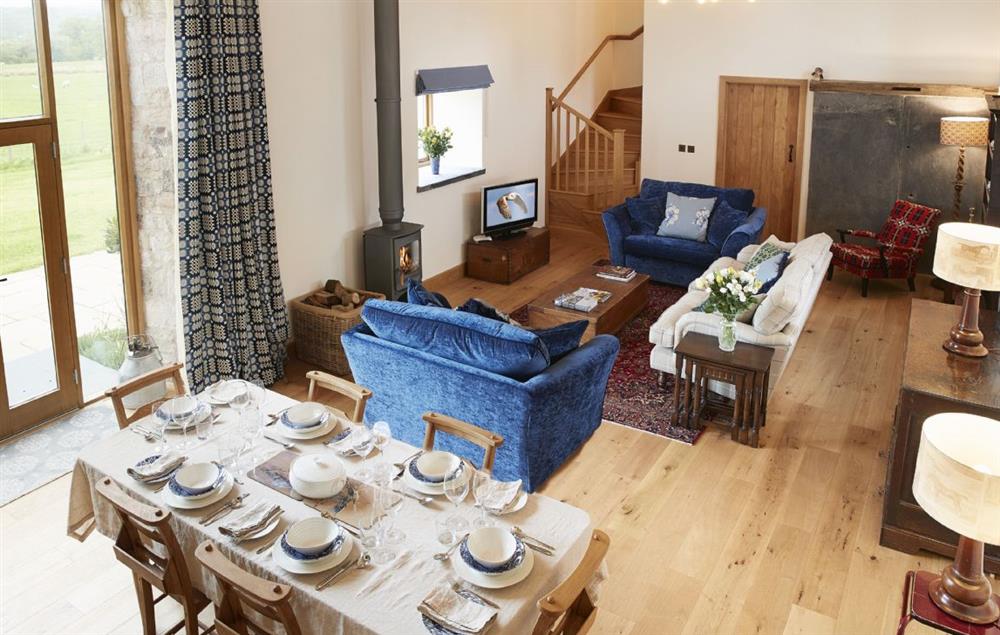 Open plan living and dining area with wood burning stove at The Longbarn at Caerfallen, Ruthin