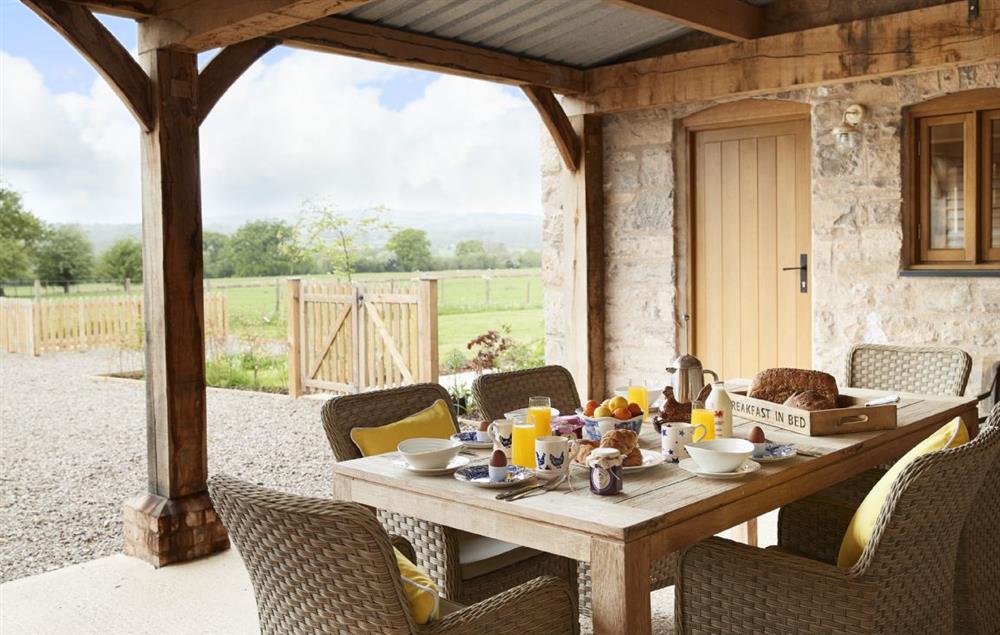 The garden room, a distinctive outdoor space with large dining table and rattan chairs to take in the lovely sunsets