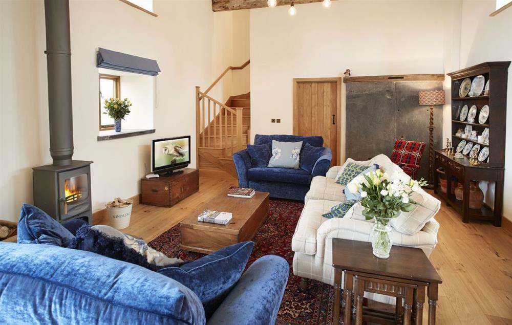 The spacious living area is filled with light and its own wood burning stove at The Longbarn at Caerfallen, Ruthin