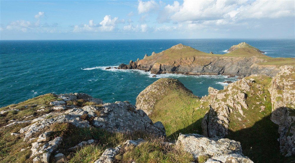 A view out to sea of a curving headland, the Rumps, at The Lugger in Boscastle, Cornwall