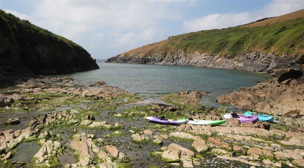 Canoes and kayaks on the beach at The Lugger in Boscastle, Cornwall
