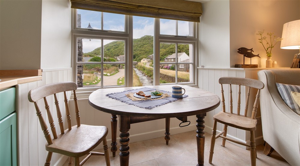 The open-plan room with sitting area, dining table and kitchen at The Lugger in Boscastle, Cornwall