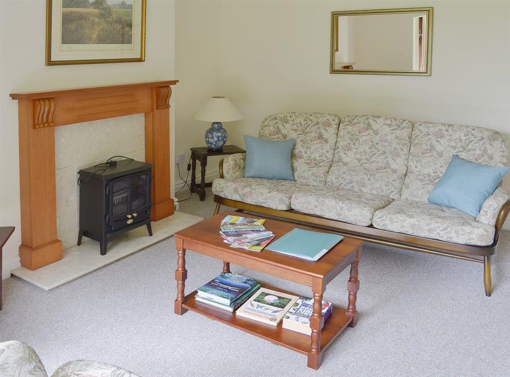 Living room with electric woodburner at The Manor House in Churchtown, near Southport, Lancashire