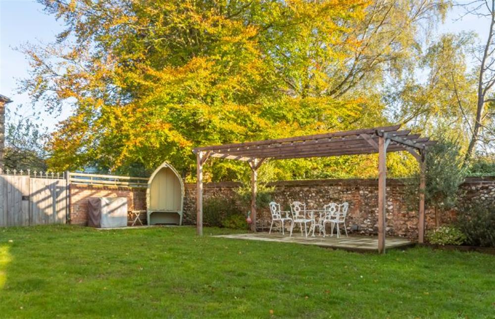 The Manse: The fully enclosed garden with a pergola and out door seating  at The Manse, South Creake near Fakenham