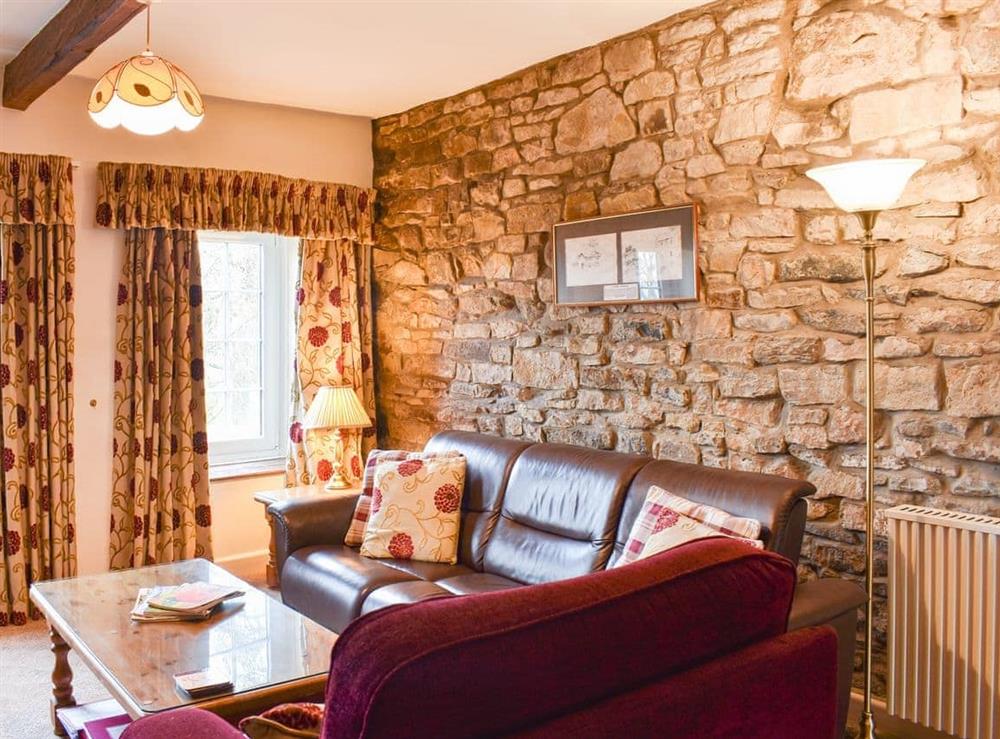 Living room with exposed stone walls and traditional furniture at The Mill in West Burton, near Aysgarth, North Yorkshire