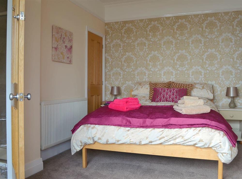 Elegant bedroom with king-size bed and en-suite at The Moorings in Grange-over-Sands, Cumbria