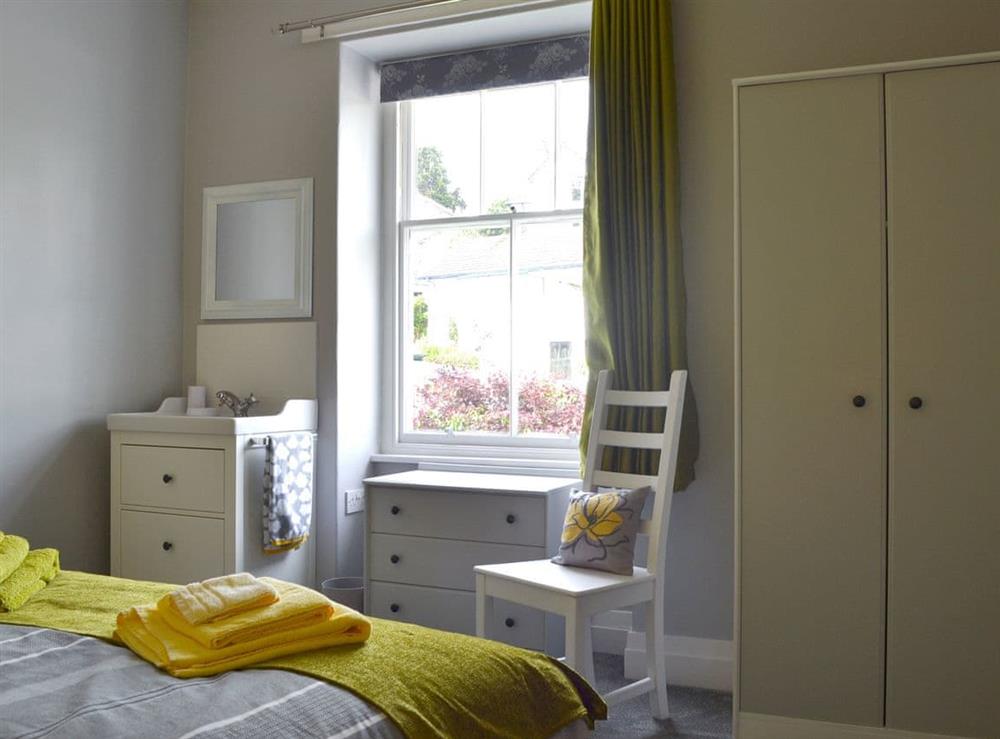 Tastefully furnished bedroom with king-size bed at The Moorings in Grange-over-Sands, Cumbria