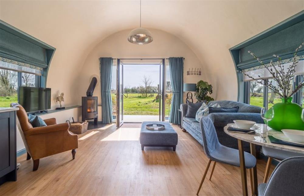 Spacious sitting area for two with a wood burning stove , overlooking the fields at The Nissen Hut at Green Valley Farm, Ubbeston