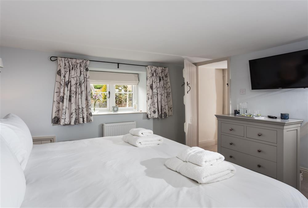 Bedroom one with a 6’ super-king size zip and link bed and television at The Nook, Guiting Power