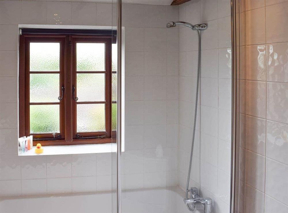 Beamed bathroom with shower over bath at The Old Bakery in Wendover, Aylesbury, Buckinghamshire