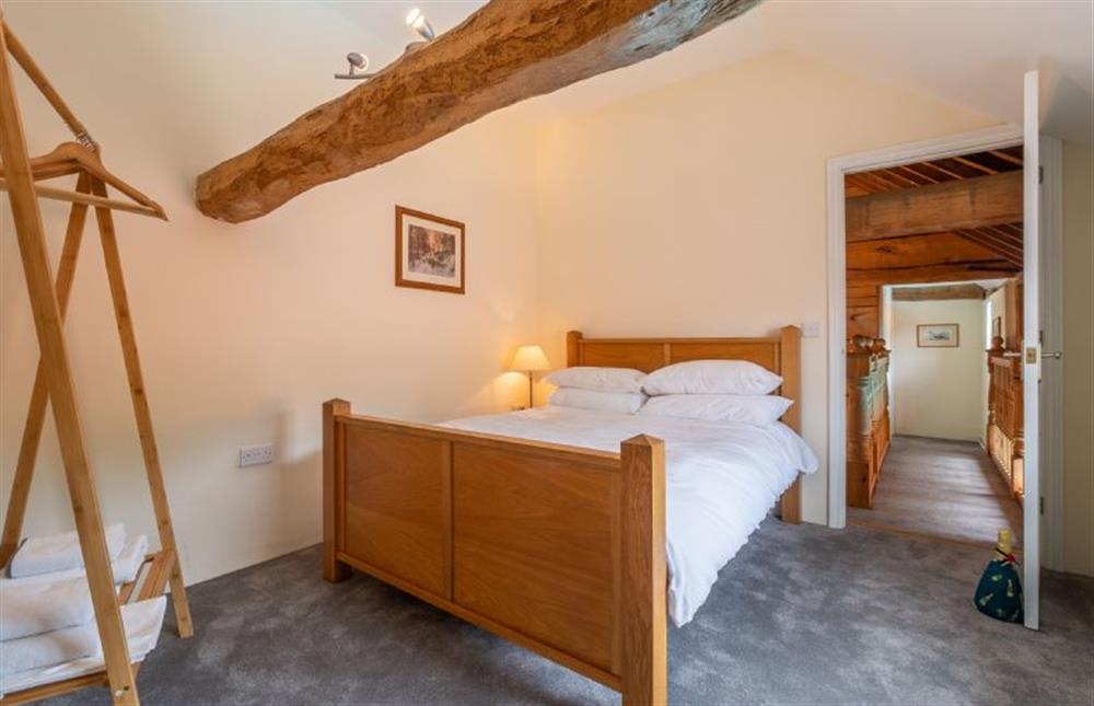 Bedroom two with low, exposed beams at The Old Barn, Semer