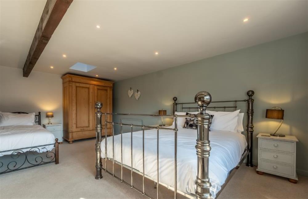First floor: Master bedroom with a king-size bed and 3ft single bed at The Old Barn, Weybourne near Holt