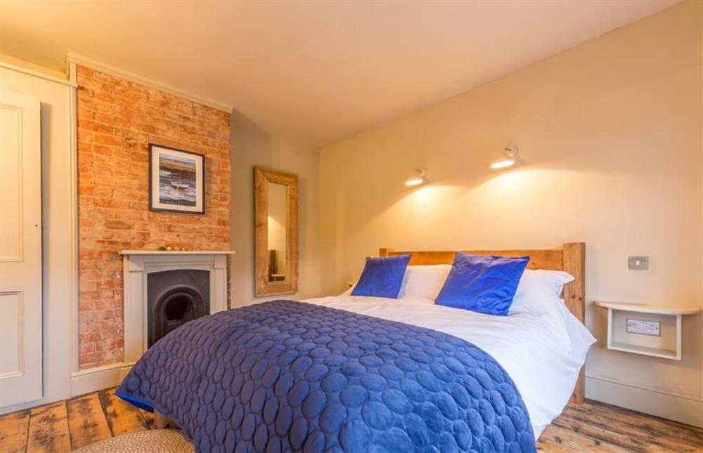First floor: The master bedroom has an ornamental fireplace at The Old Butchers Shop, Heacham near Kings Lynn