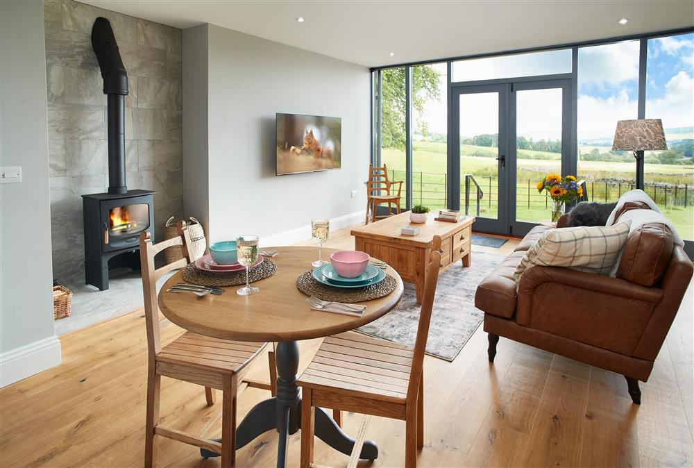Ground floor: Open-plan living space with a cosy wood burning stove and doors leading out to open views of the rolling green hills