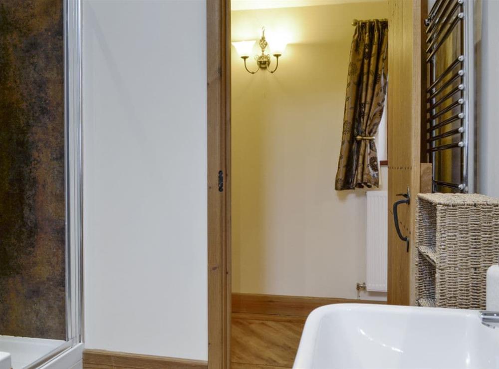 Family bathroom with shower cubicle, bath and heated towel rail at The Old Byre in Dearham, near Maryport, Cumbria