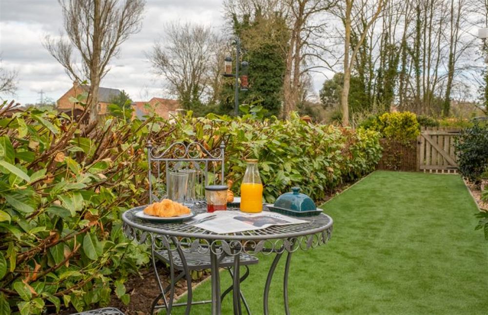 A quite area of the garden with a bistro table and chairs at The Old Chapel, Pentney near Kings Lynn