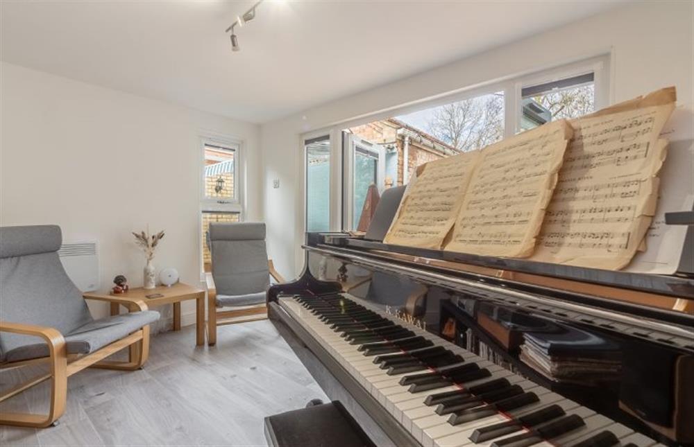 The music room with seating and piano at The Old Chapel, Pentney near Kings Lynn