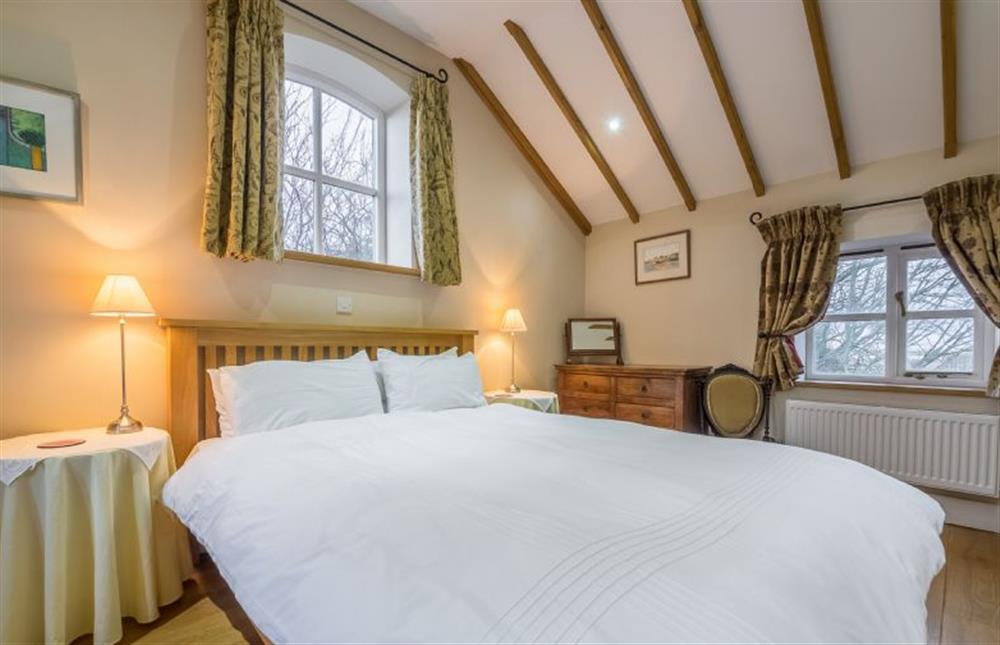 First floor: Triple aspect Master bedroom with King-size bed at The Old Coach House, Brancaster Staithe near Kings Lynn