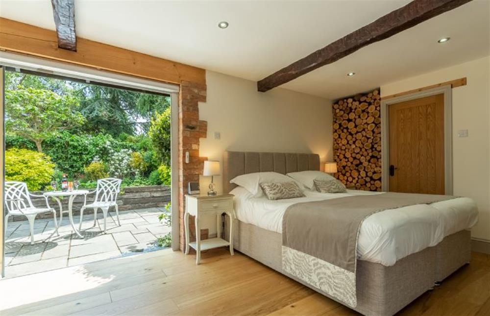 Bedroom area with bi-fold doors to courtyard garden at The Old Cow Shed, Pott Row near Kings Lynn